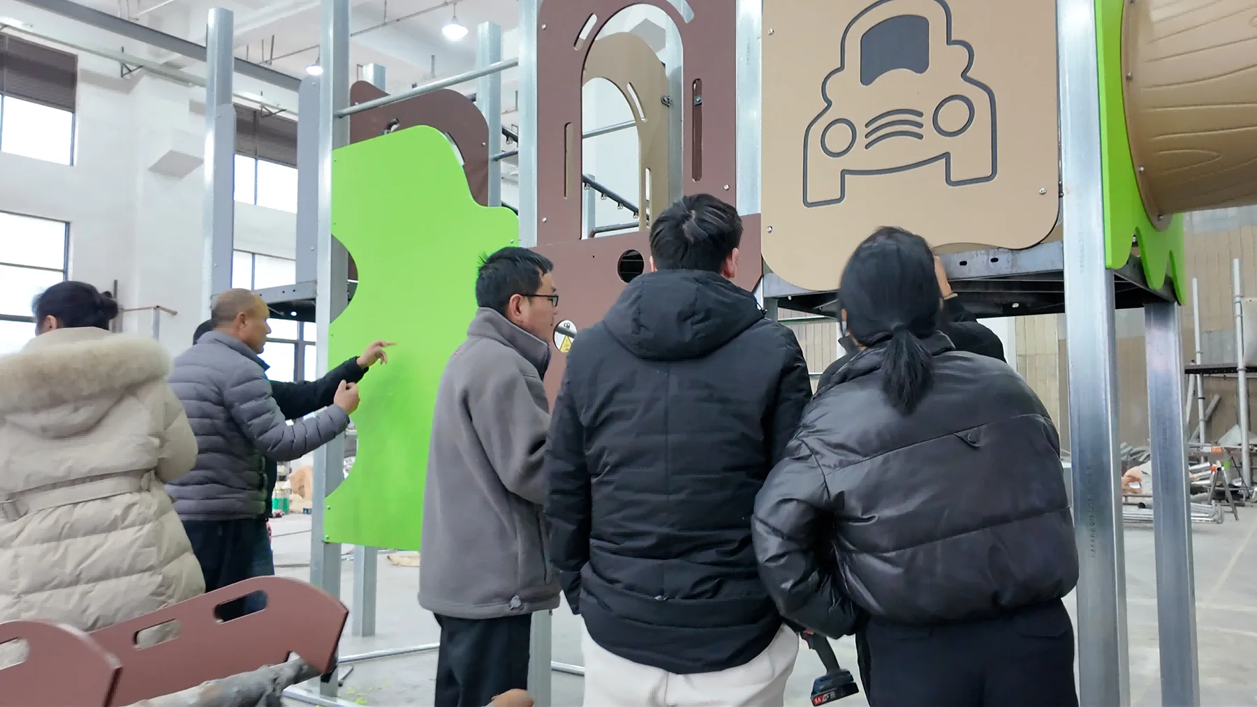 ZZRS team checking playground components during factory trial assembly before shipment