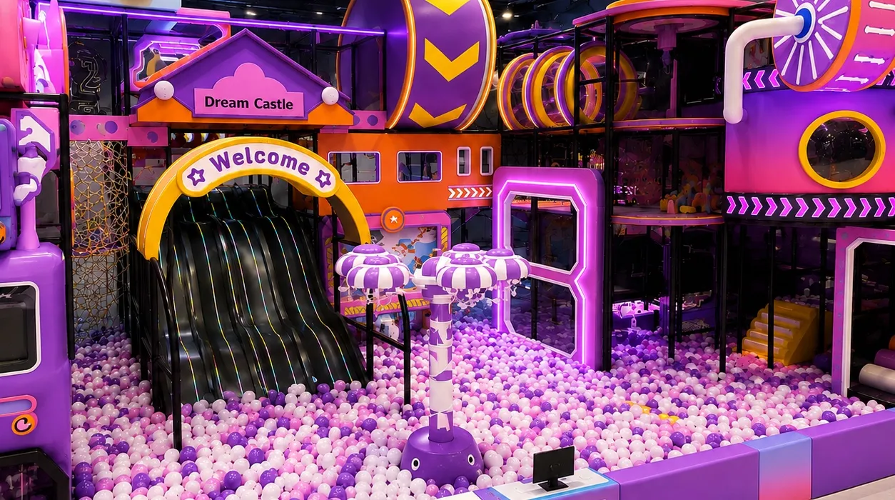 Purple multi-level indoor playground installation with slides, tunnels and a ball pool